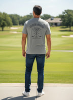 Man wearing a grey Scooter Martini tri-blend t-shirt with a golf and martini glass logo on the back at a golf course.