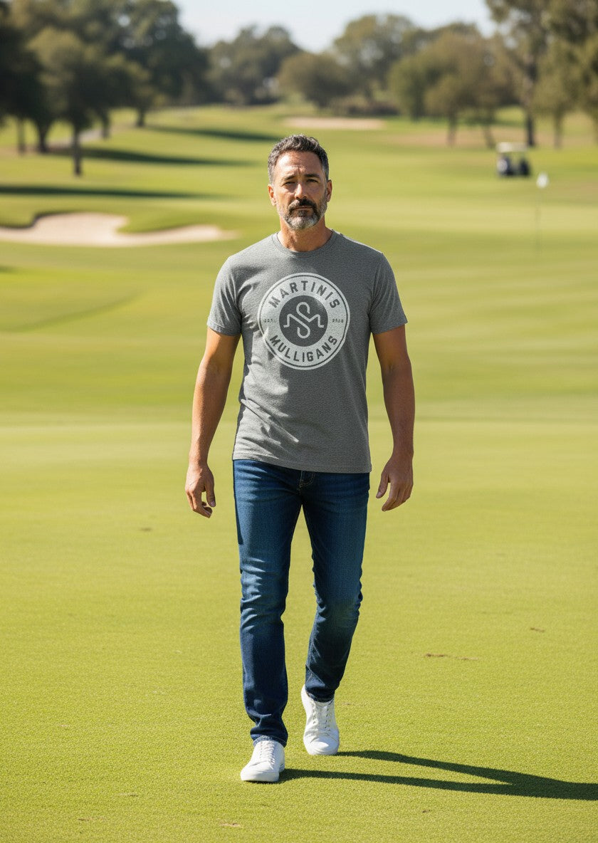 Man wearing a grey Scooter Martini tri-blend t-shirt with a white circular logo on a golf course.